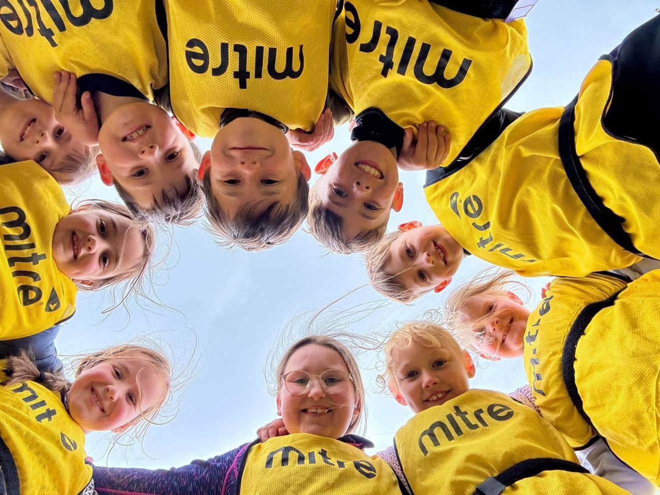 Kids in circle smiling down at camera below