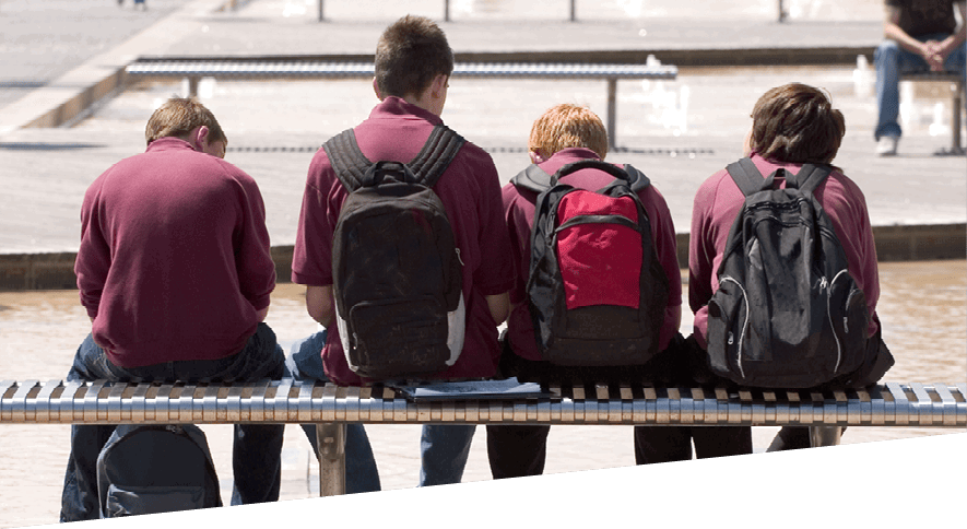 Group of teenage boys sat inactive on a bench