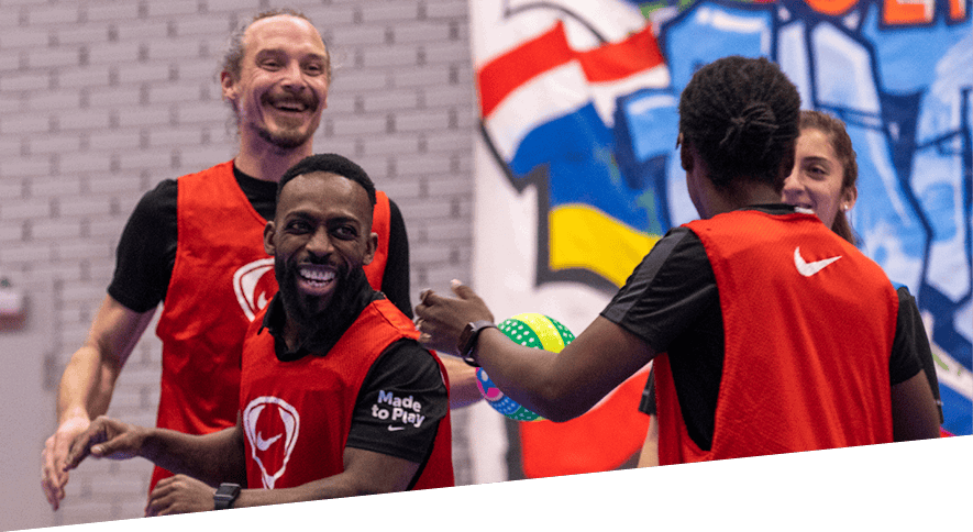 Group of adults smiling and having fun on the Coach Educators programme